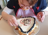 Deelneemster versiert zelfgebakken hartvormige taart