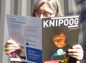 Een vrouw leest de nieuwe Knipoog.