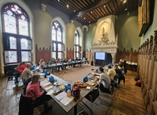 Zeventien PsyCoDiVIA-deelnemers in overleg, aan tafels die in U-vorm tegen elkaar geplaatst zijn en de middeleeuwse vergaderzaal helemaal vullen. Een projectiescherm staat voor de imposante haard. Dit voelt echt aan als thuis voor Licht en Liefde: de uitwisseling van deskundigheid (= Licht) in een warme omgeving (= Liefde) is het unieke recept voor succes bij ons werk!