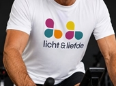 Cliff op zijn spinningfiets, met T-shirt van Licht en Liefde